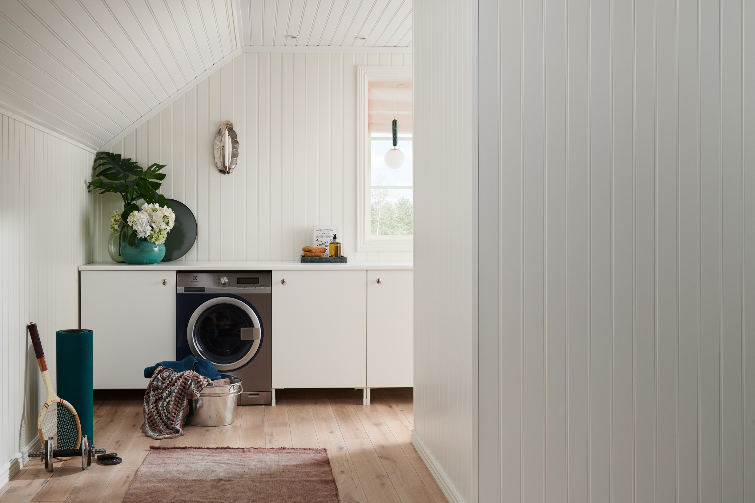 Tvättstuga med vitmålad panel på väggar och i tak