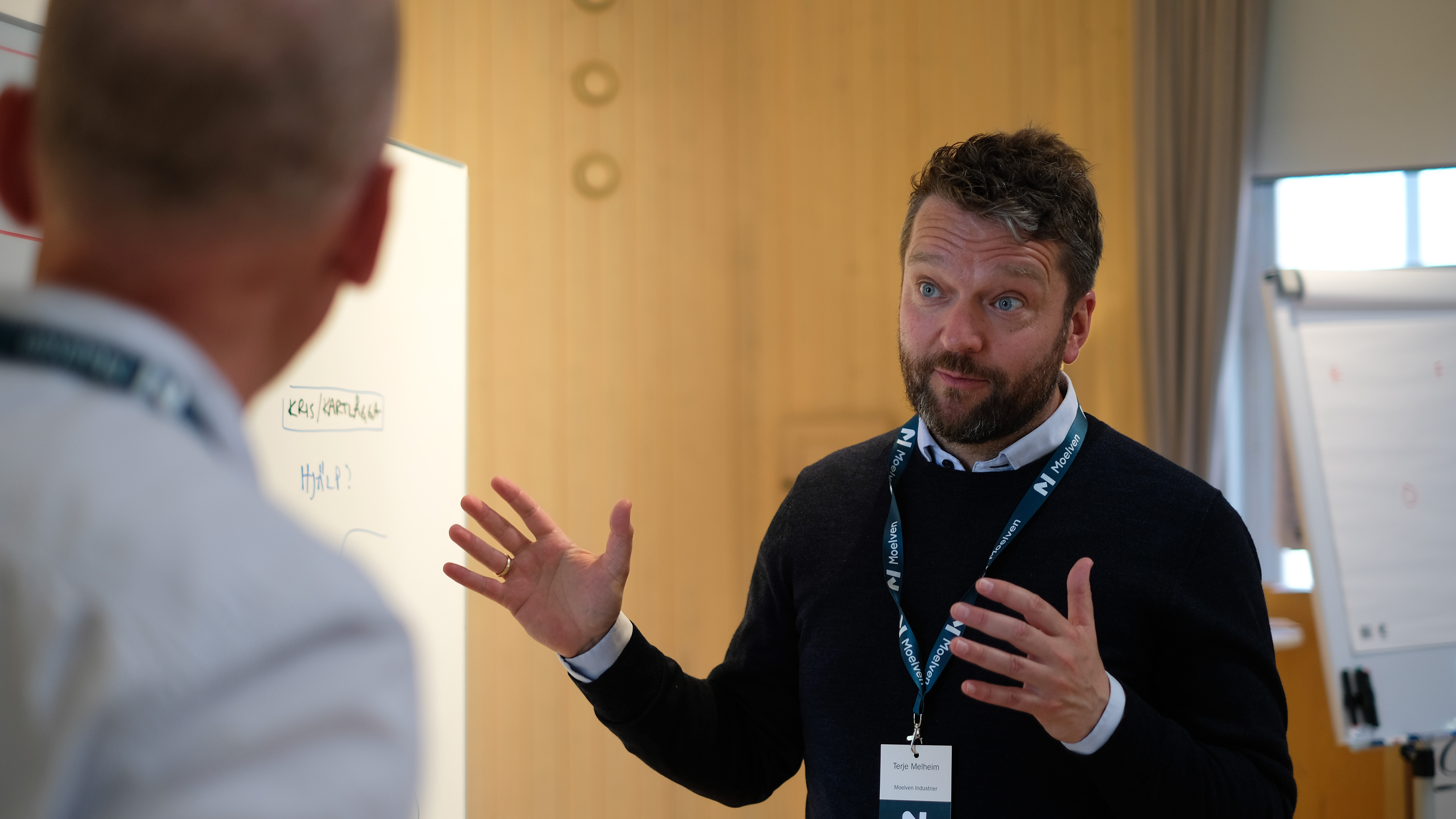 Terje Melheim. Mann snakker og gestikulerer med armene til kursdeltaker. Fotografi