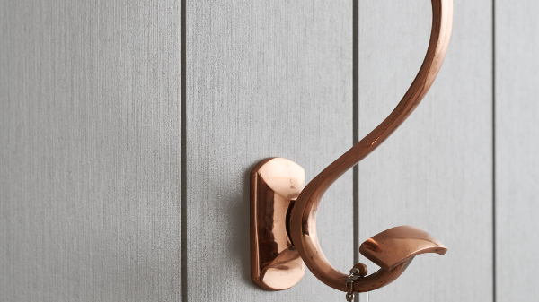 Grå träpanel med en krok i brons