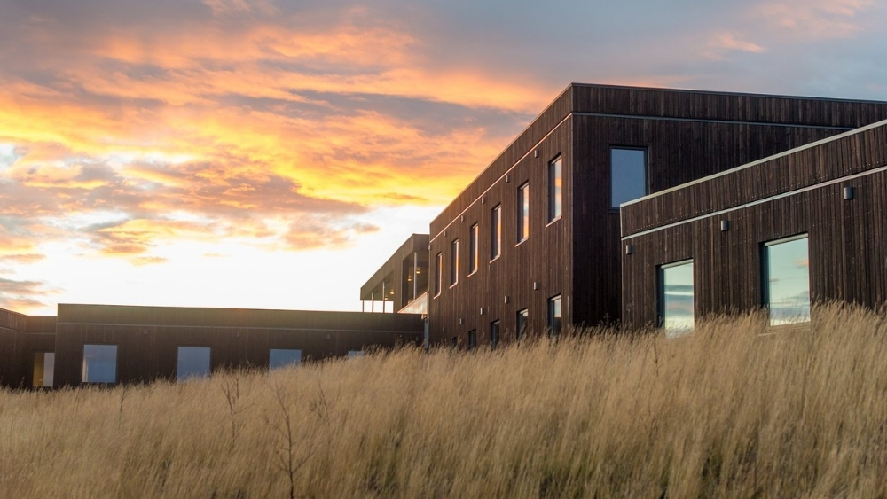 Modubygd hotell med fargesprakende himmel i bakgrunnen