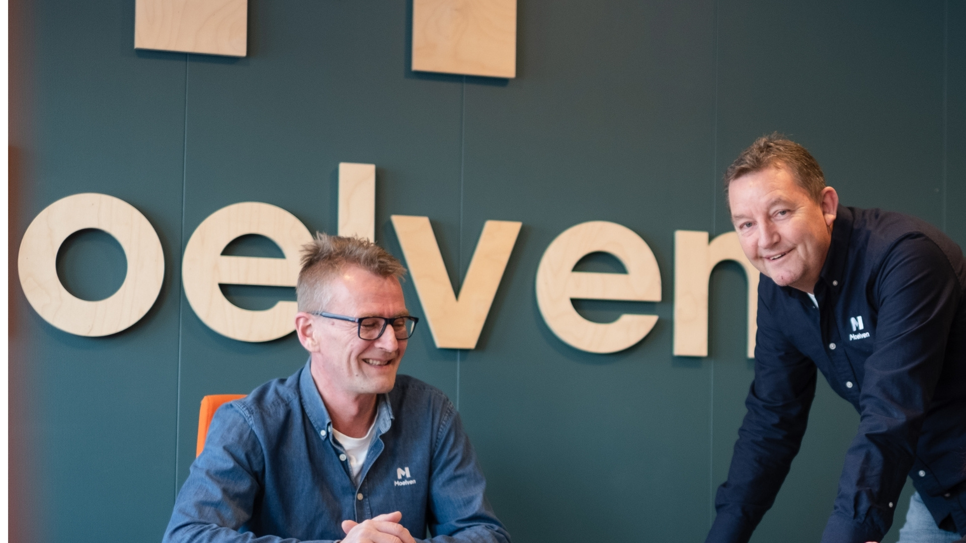 Zwei lächelnde Männer mit Moelven-Hemden.