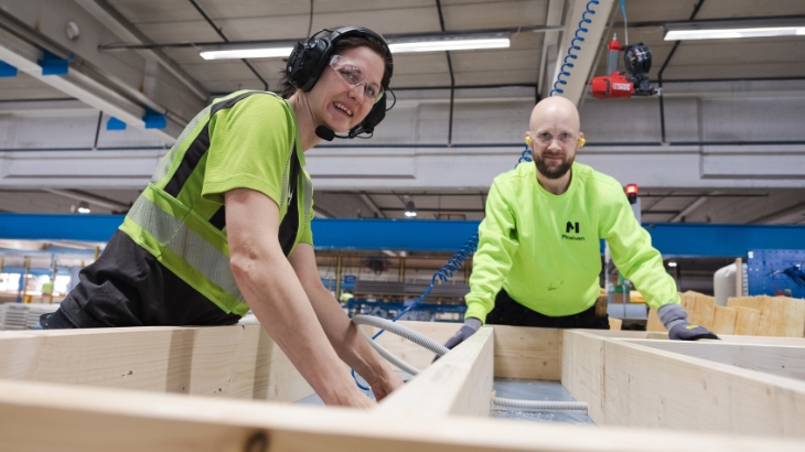 Zwei Kollegen in einer Fabrik, die zusammenarbeiten.